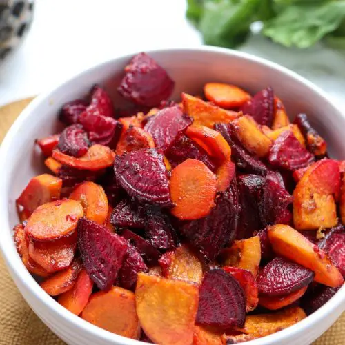 close up of a bowl of roasted beets, carrots and sweet potatoes