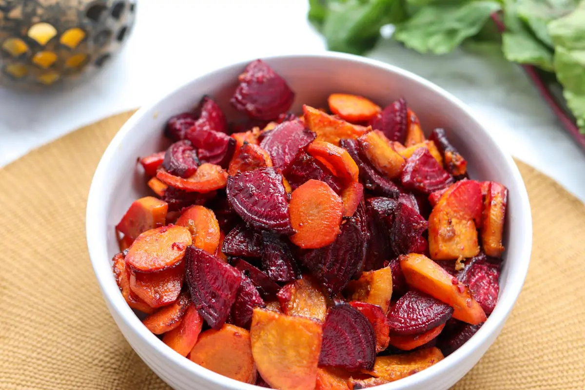 close up of a bowl of roasted beets, carrots and sweet potatoes