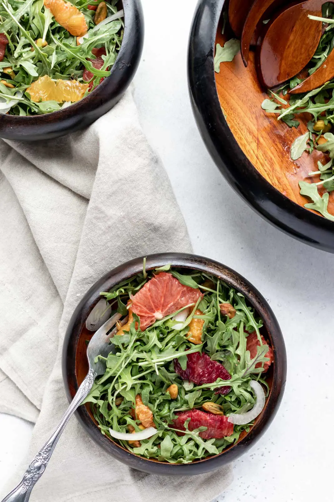 overhead shot of salad with pistachios, fruit and arugula