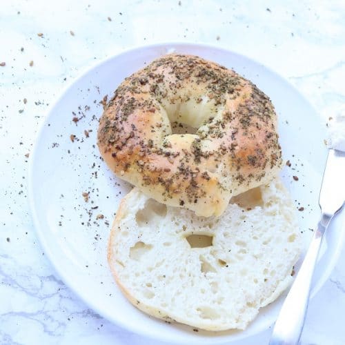 sliced zaatar bagel on a white plate