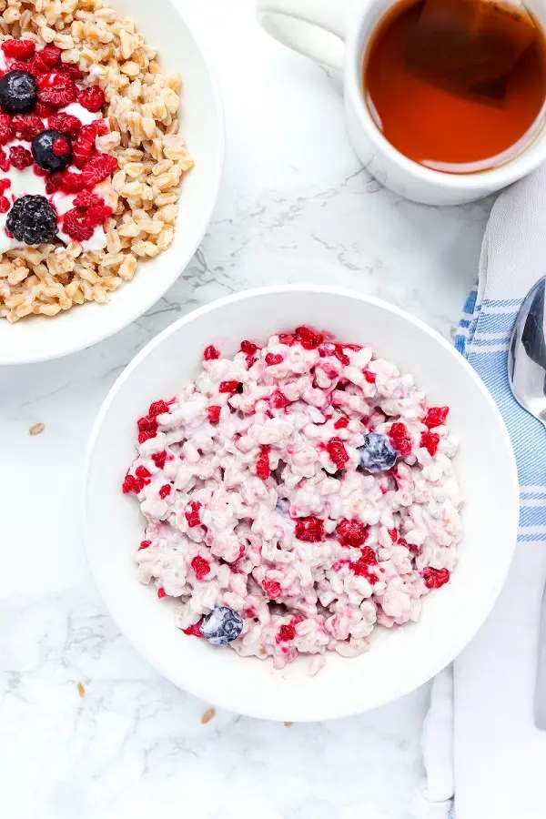 Farro Breakfast Bowl Yogurt and berries mixed with farro served in a white bowl