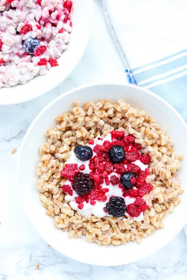 blueberries and raspberries topping a bowl of farro and yogurt