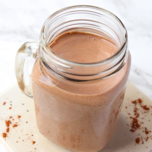 chocolate chia smoothie in a glass mug with sprinkled cacao powder