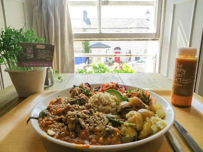 eating a buddha bowl from the happy pear in Ireland