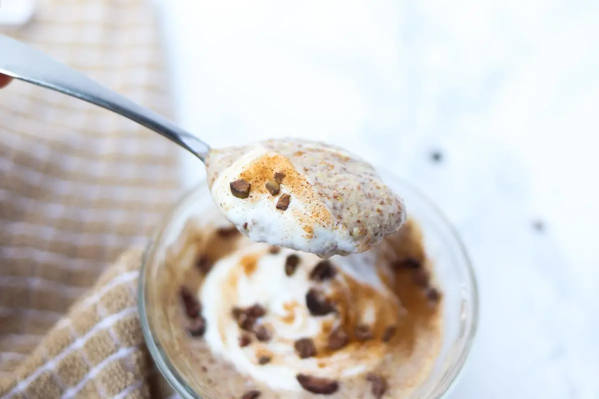 close up of a spoonful of flax pudding mixed with yogurt, cinnamon and cacao nibs