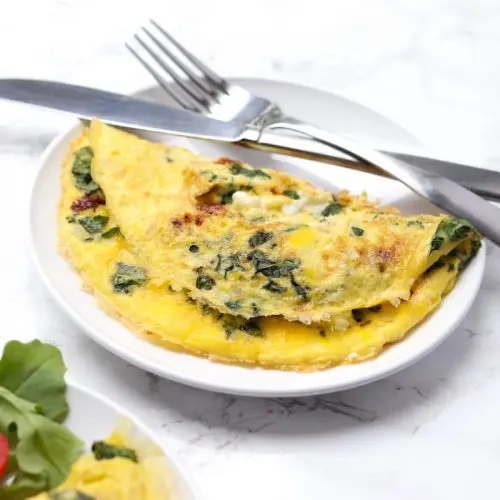 omelette stuffed with kale served on a white plate