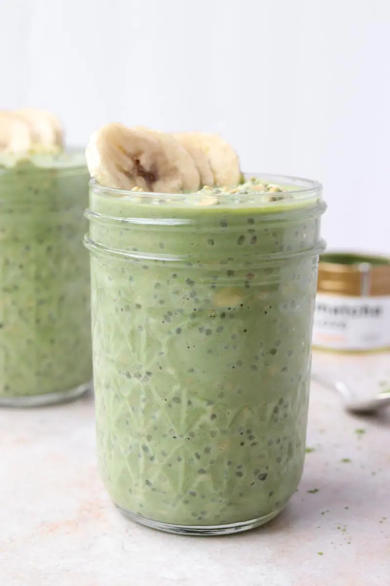 Close up of a glass jar of green overnight oats with chia seeds