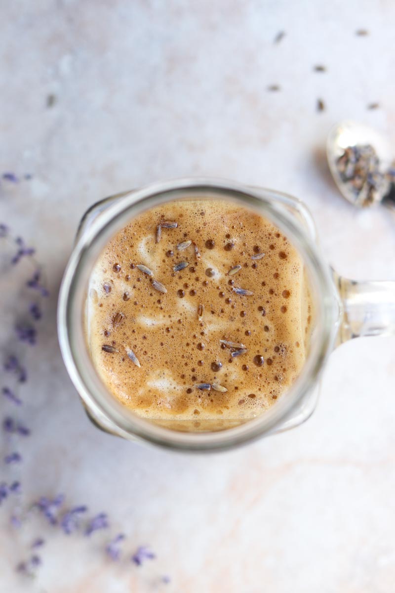 overhead shot of a foamy latte with lavender buds sprinkled on top
