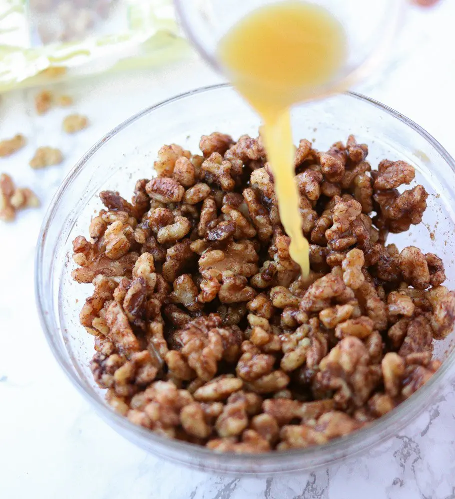 spiced walnuts with orange juice being pouring over top