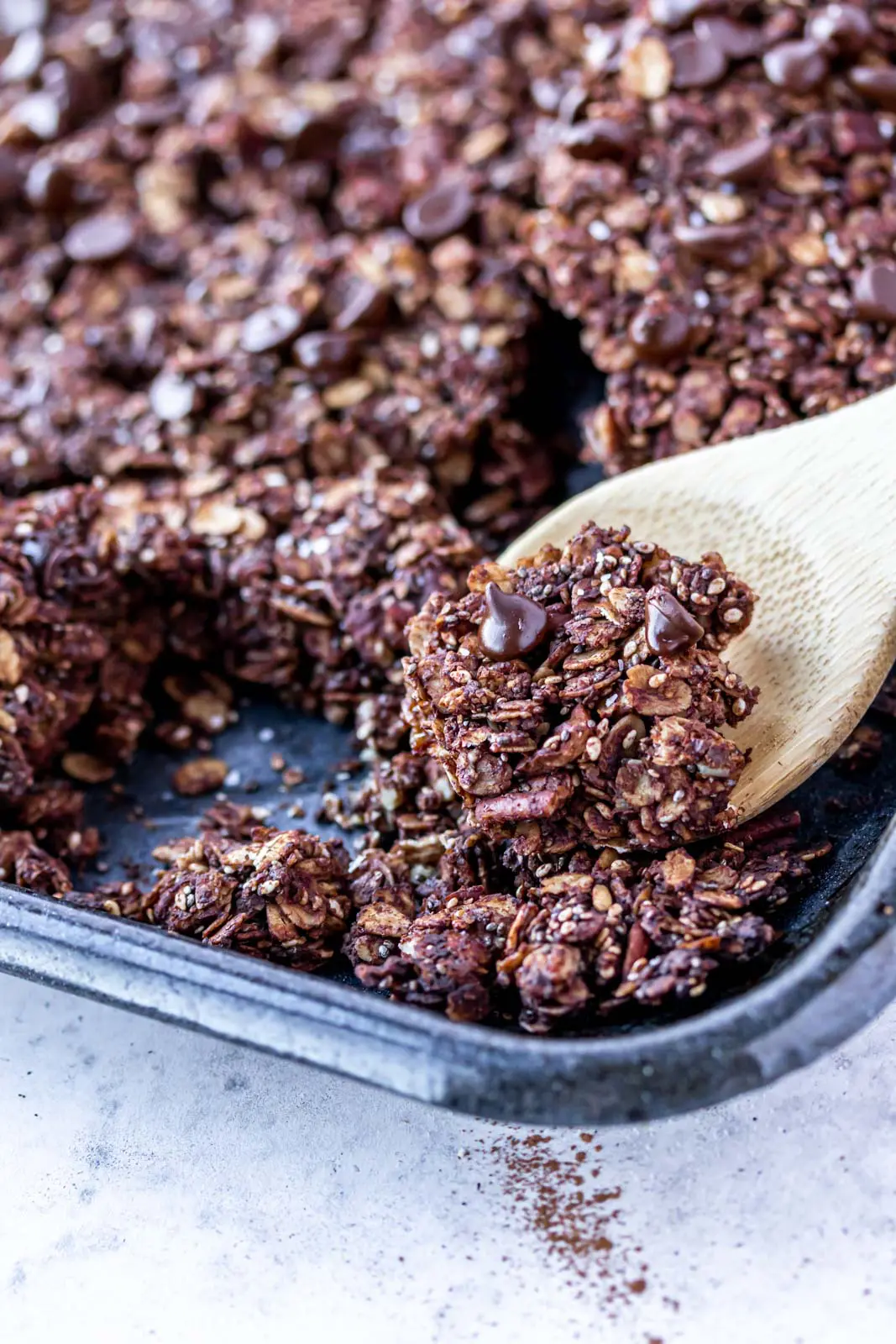 spoon scoping a chunk of granola with chocolate chips