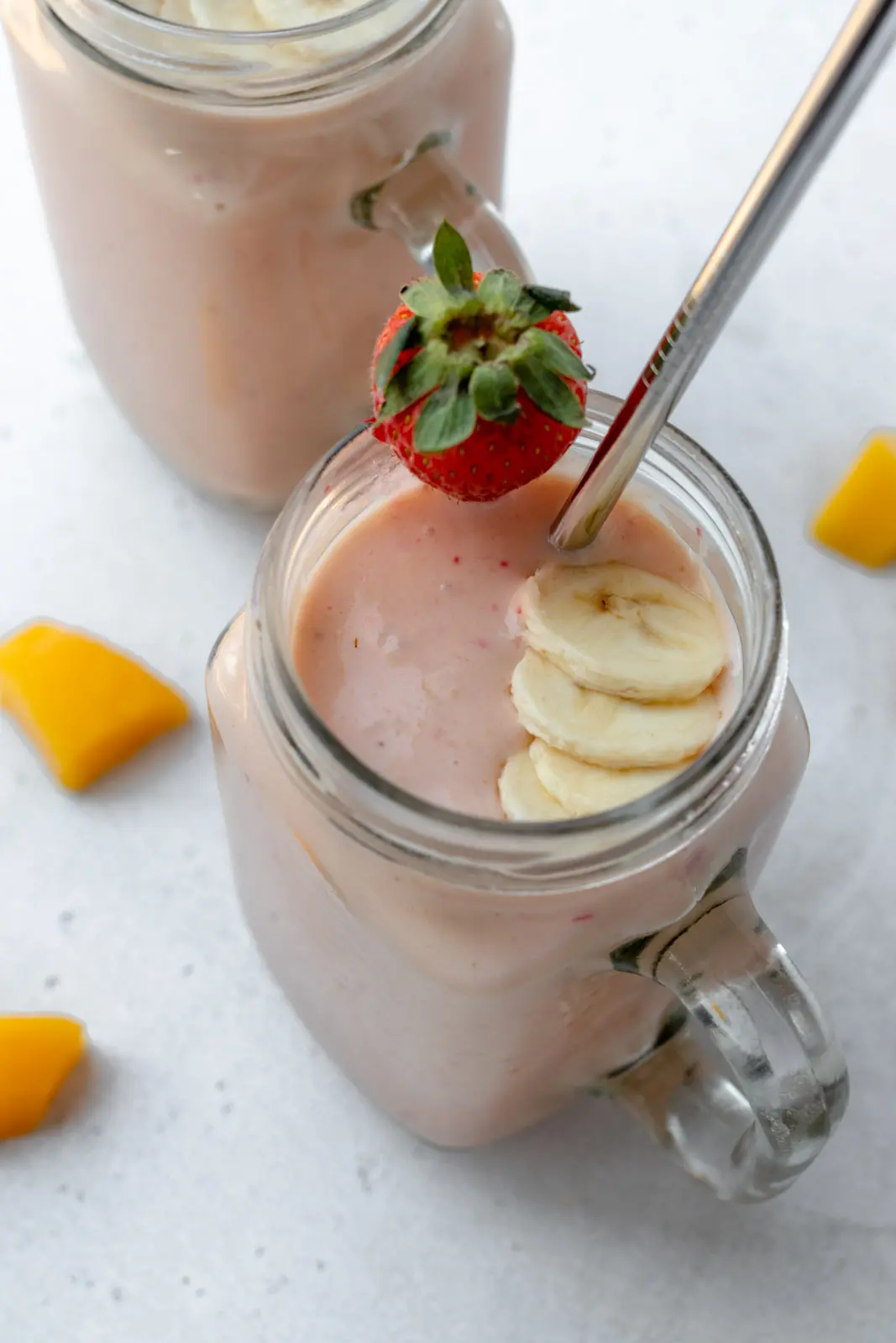 mango strawberry banana smoothie in glasses