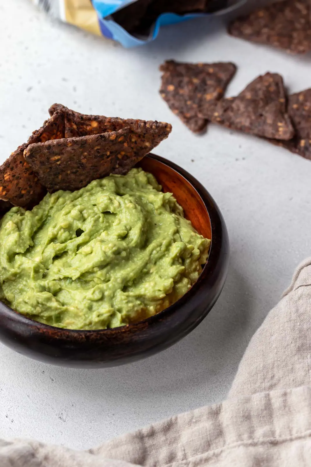 chips dunked in a bowl of guacamole