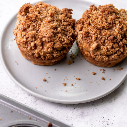 two banana carrot muffins with crumble on a plate