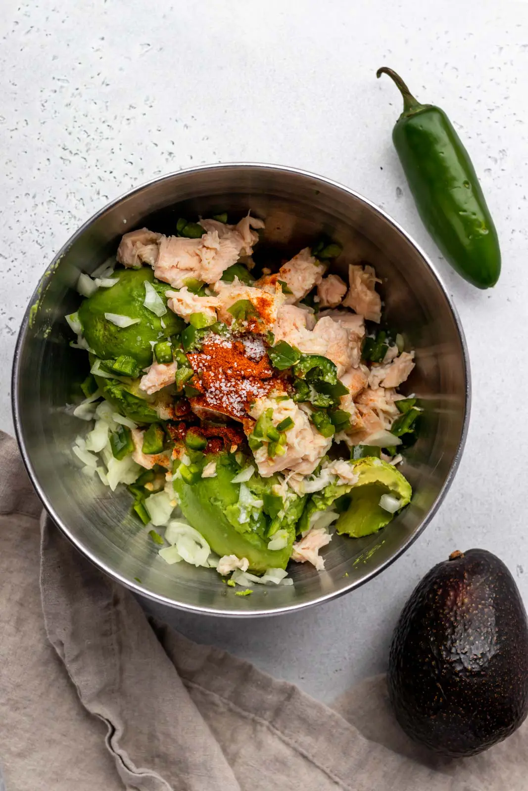 mixing bowl of canned chicken, avocado, jalapeno and spices