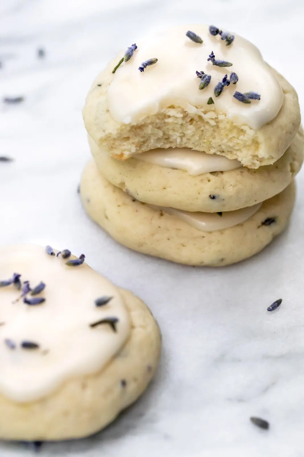 three stacked glazed cookies with lavender buds