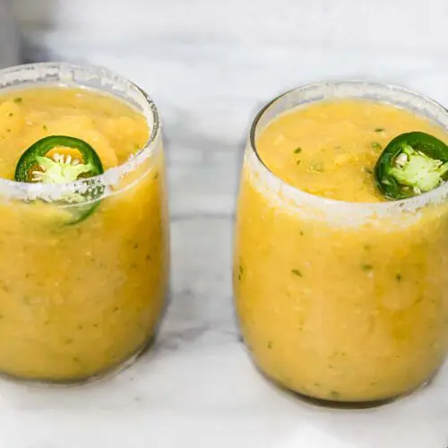 two glasses of frozen mango margarita with jalapeno