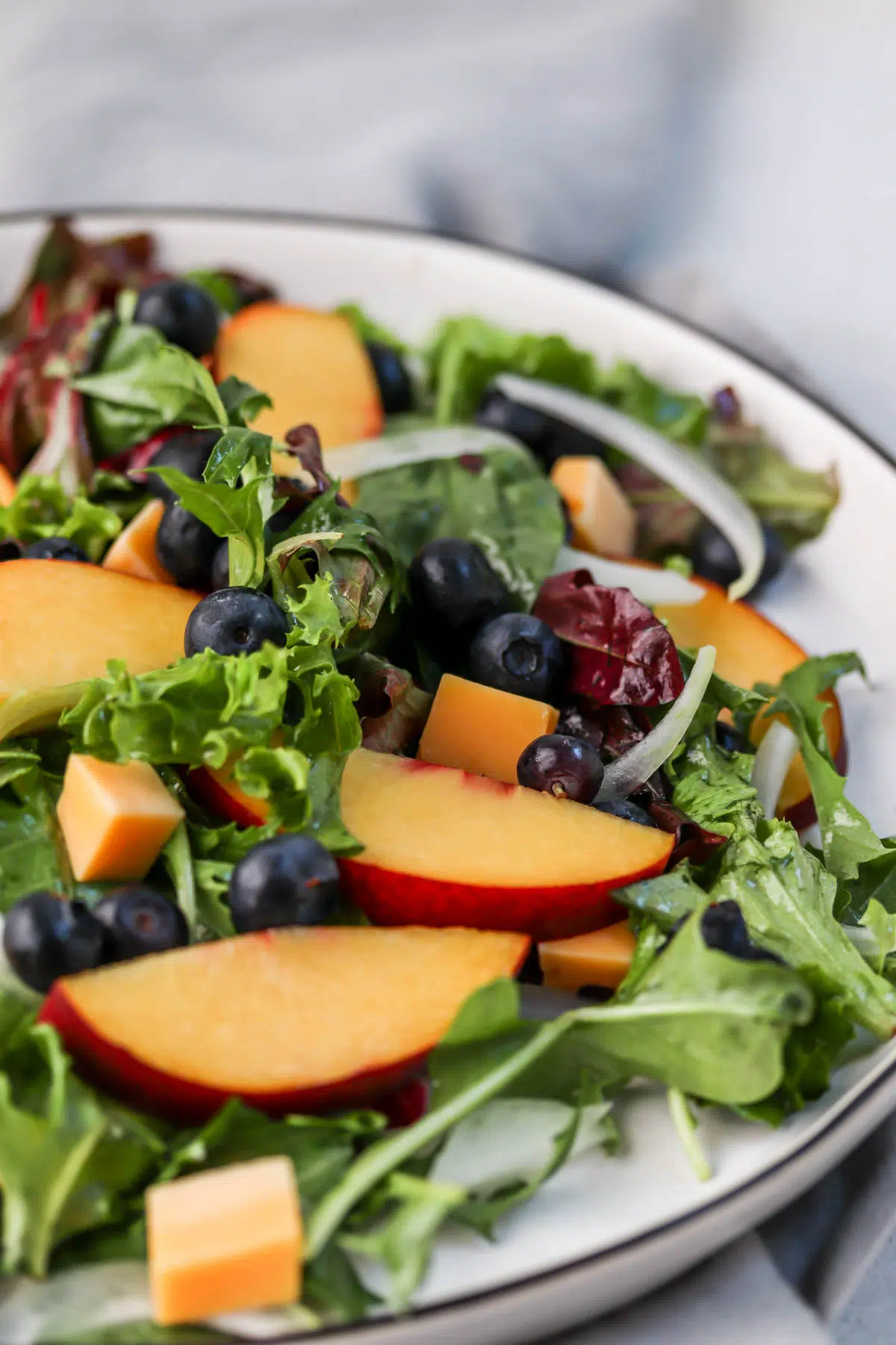 blueberries and peaches on salad greens