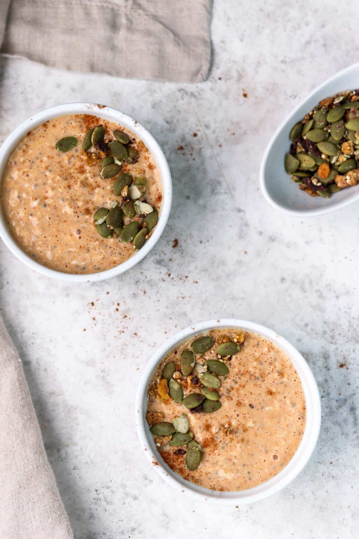 small bowls of overnight oats with pumpkin seeds