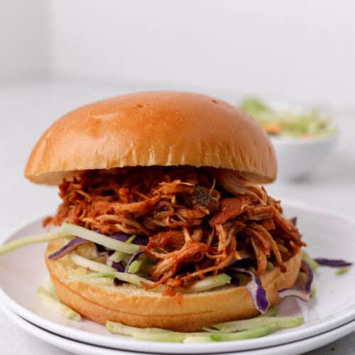 Shredded chicken sandwich on a plate.