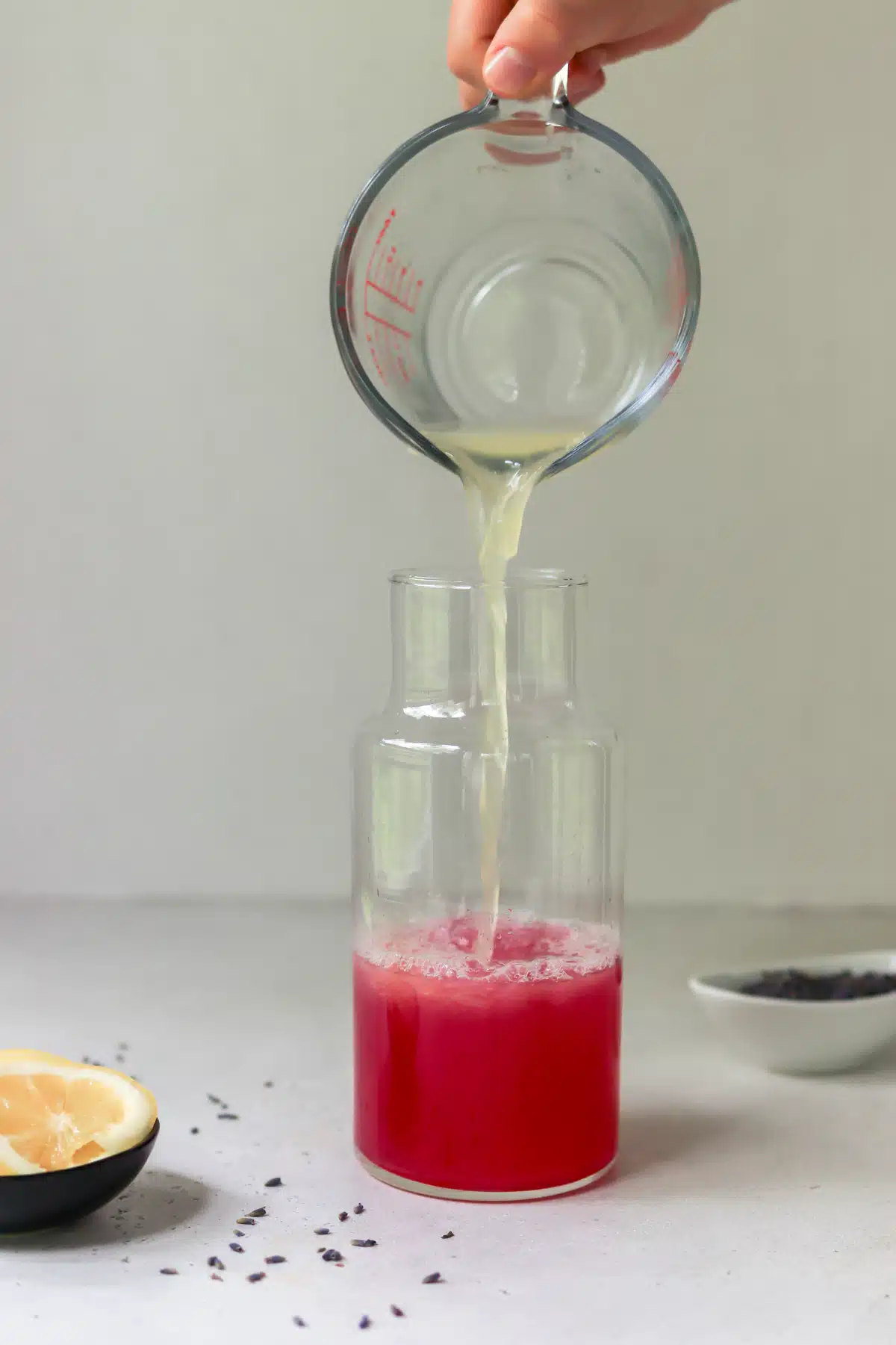 Lemon juice pouring into lavender syrup